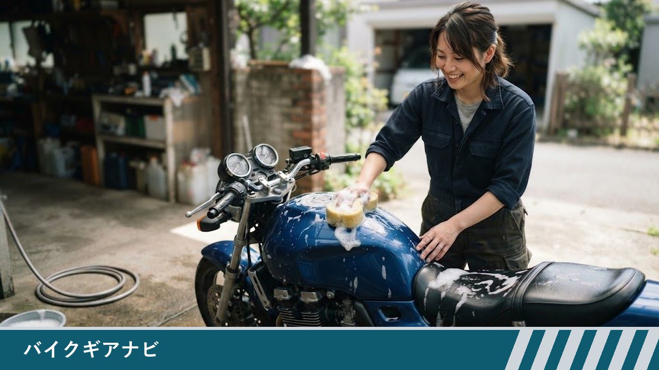 自宅の庭先で、女性が青いバイクのタンクの上面に泡をつけたスポンジを当てて洗っている様子