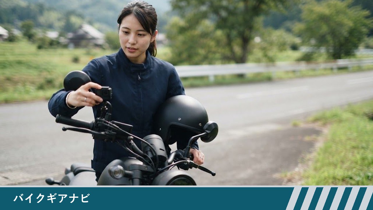 停車したバイクのハンドル近くに付けた小型カメラの向きを、女性ライダーが素手で調整している様子